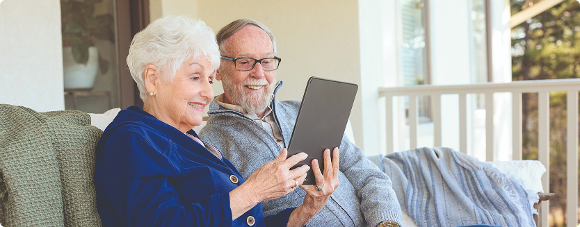Older couple happily using tablet together.