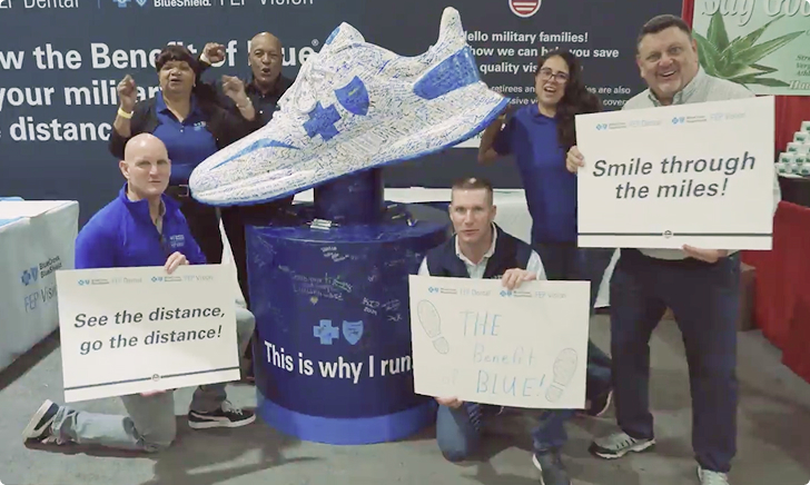 Team posing beside an oversized, signed BCBS shoe at a wellness event.